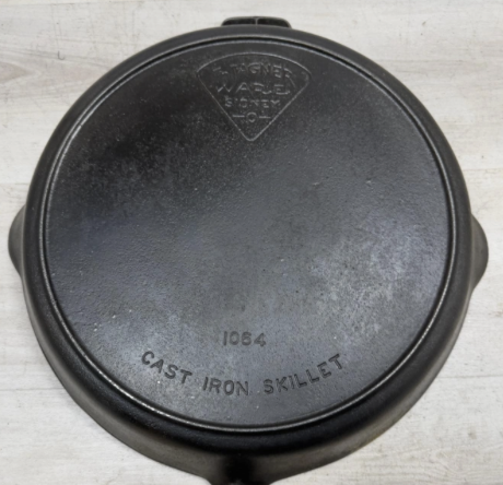 Bottom of Wagner "Pie Logo" Cast Iron Skillet no. 14 with heat ring, catalog number 1063. Sold for $550 to an on-site bidder.